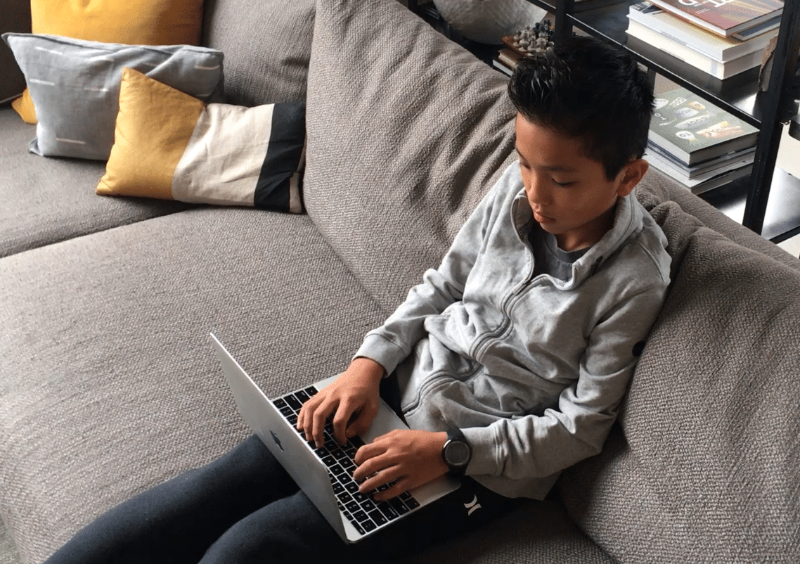 13 year old student coding on couch